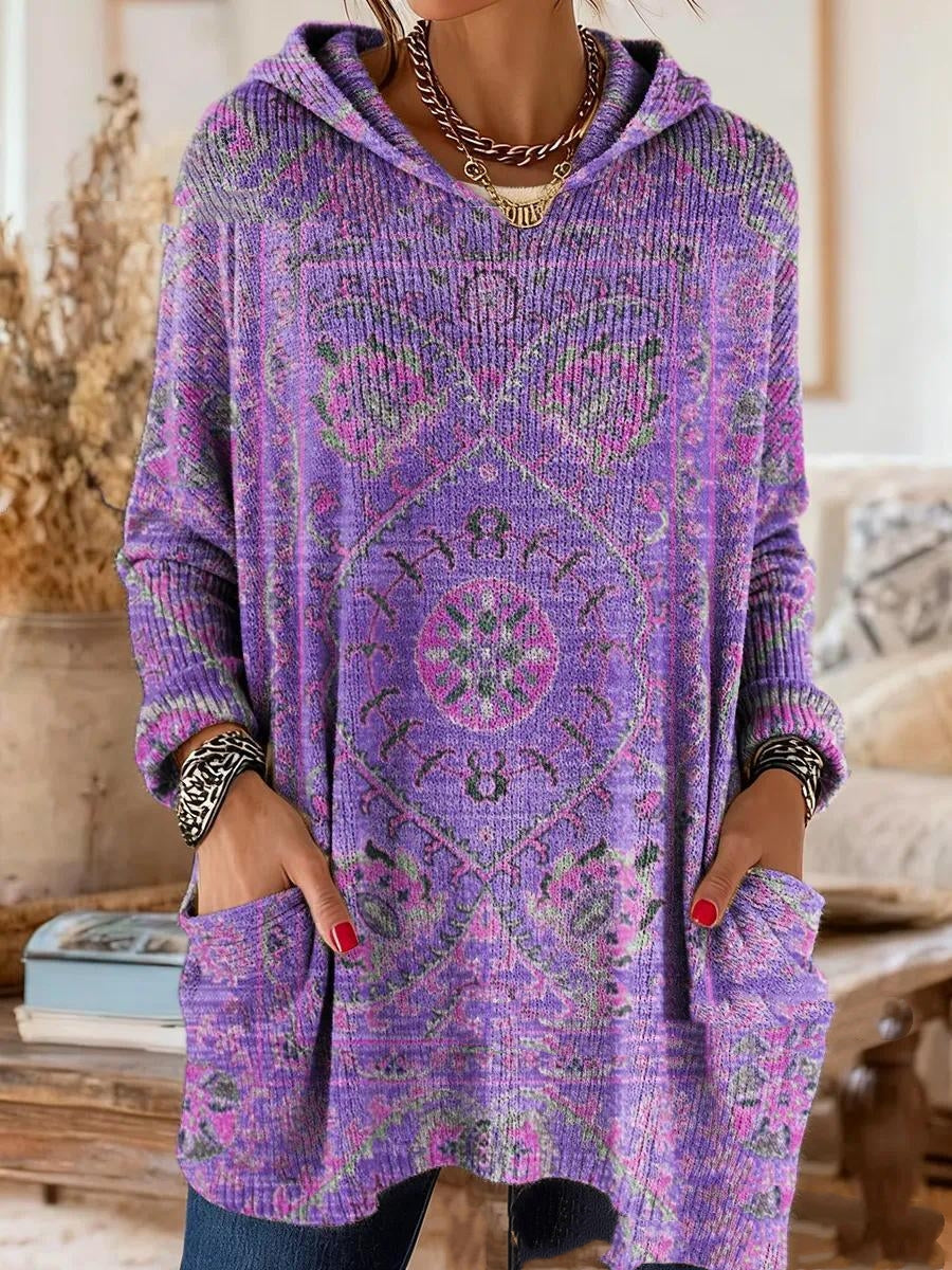 Purple version of the ribbed hooded tunic with a pink and green medallion print, worn with hands in the patch pockets. 2