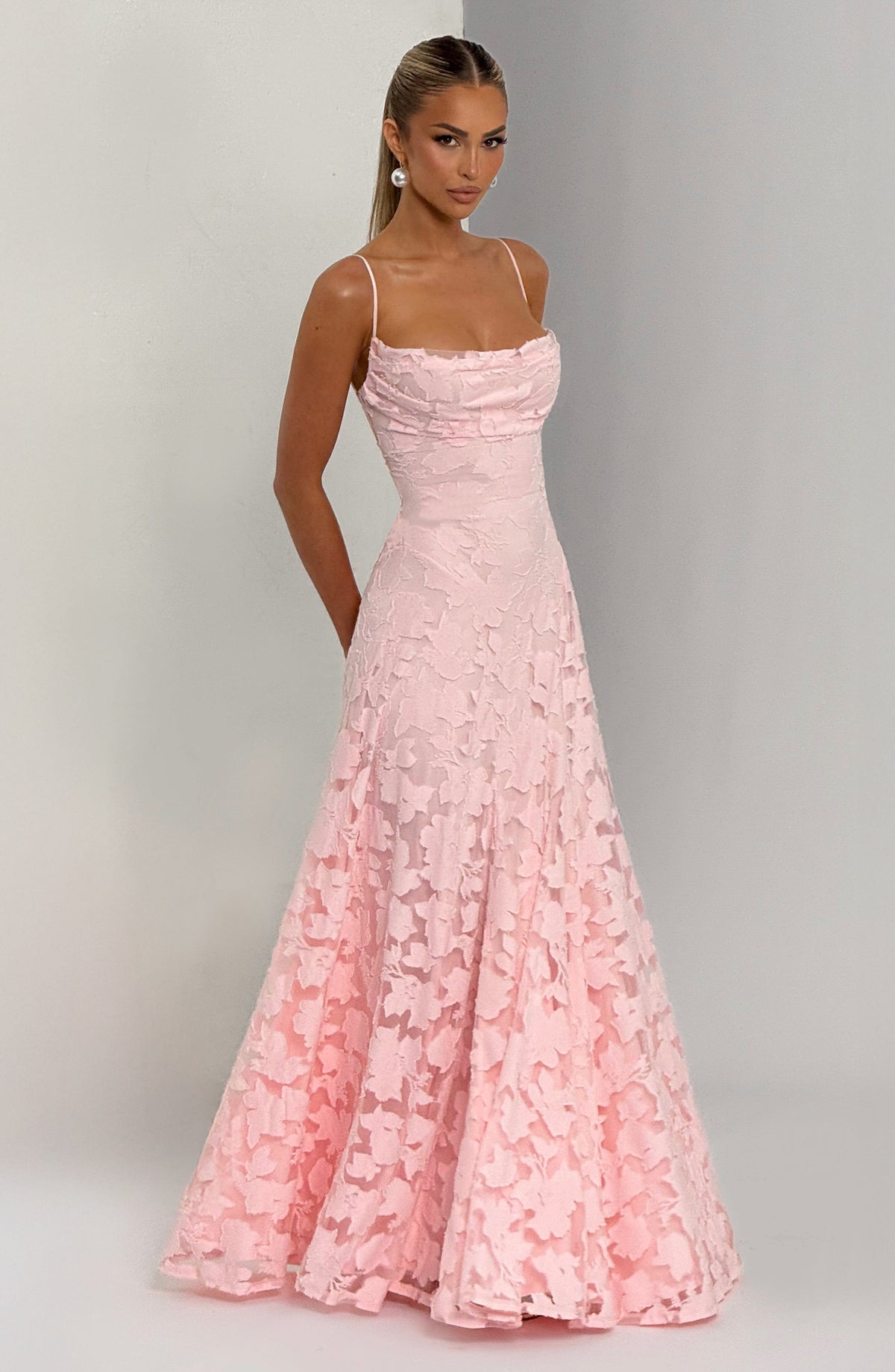 Pale pink floral maxi dress worn by a model against a grey backdrop, angled to show the flared skirt. 4
