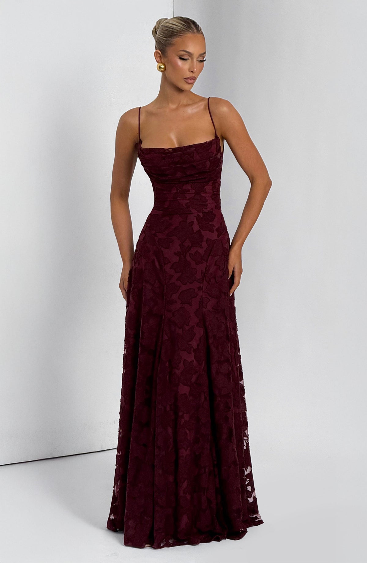Deep burgundy floral maxi dress worn by a model with a bun, showing the cowl neckline and thin straps. 17