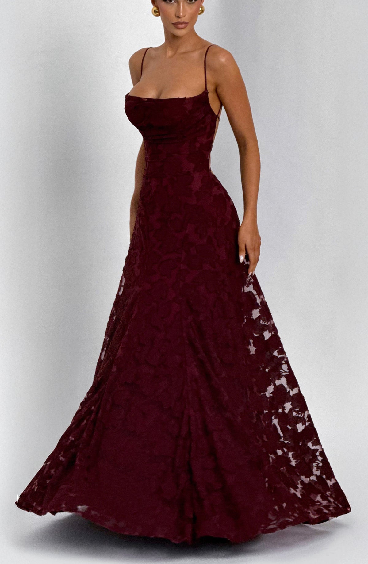 Burgundy floral maxi dress with the sheer-patterned skirt lifted and fanned out, worn with gold earrings. 20