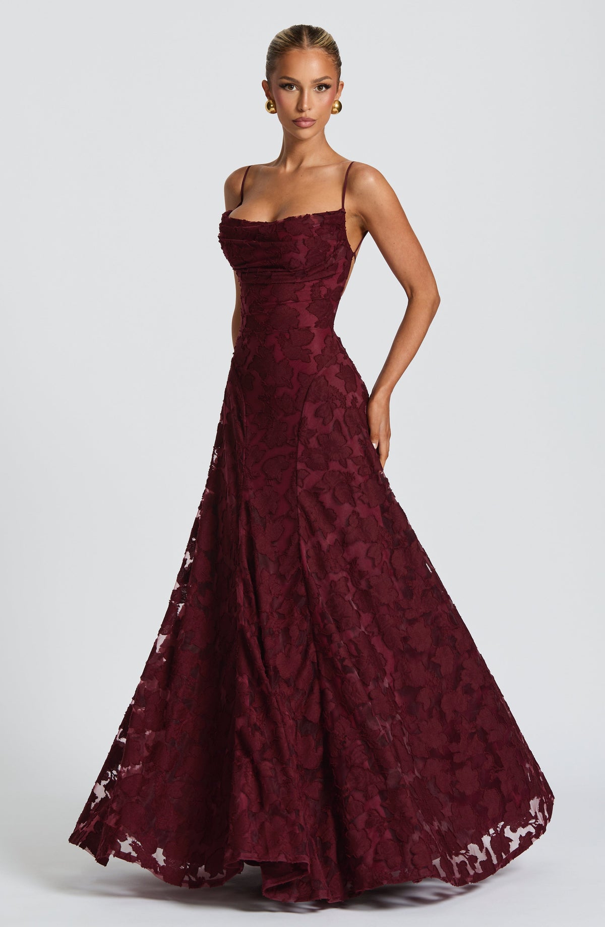 Three-quarter view of the burgundy floral maxi dress, with the full flared skirt and open back ties visible. 19
