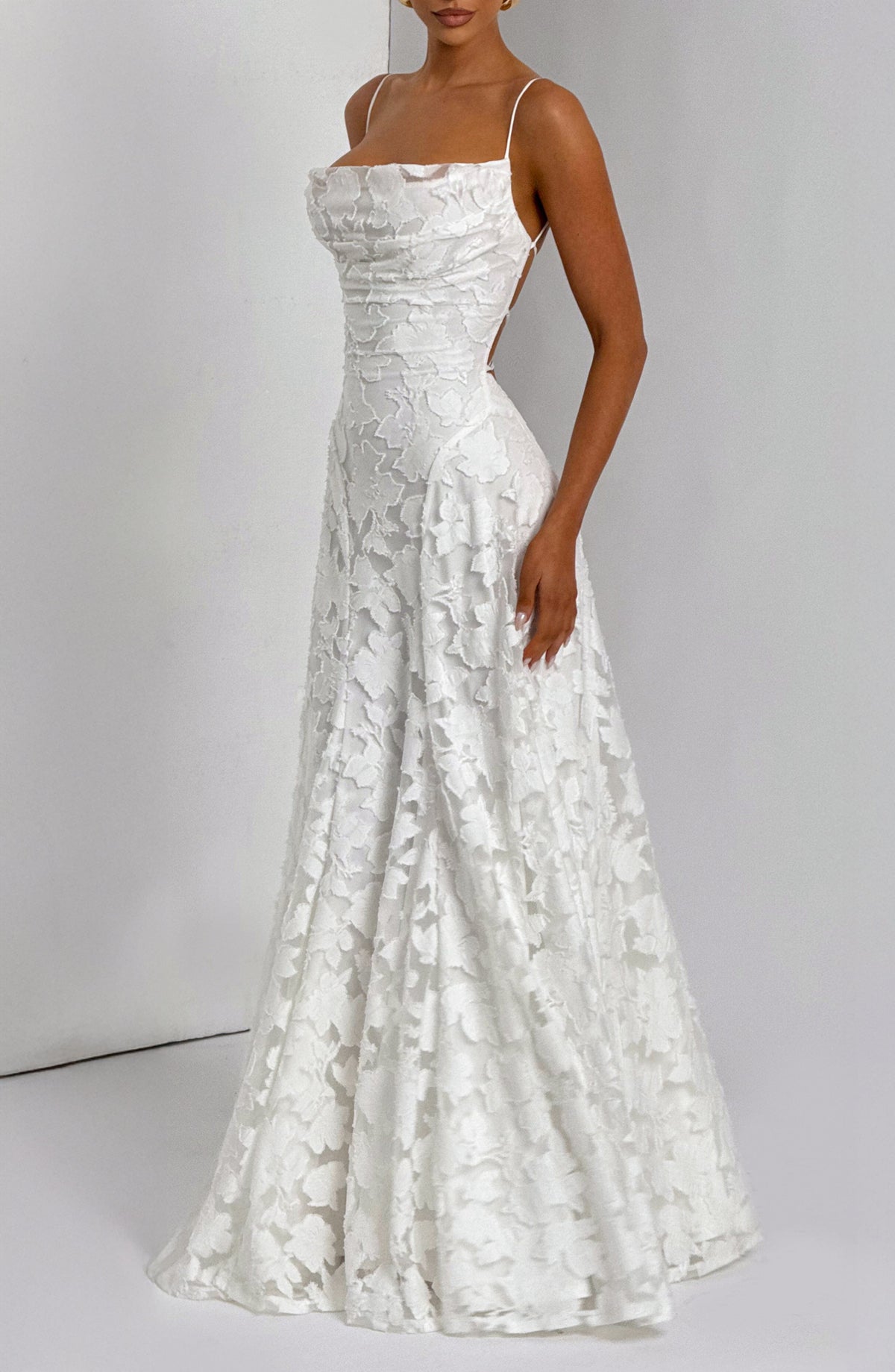 Cropped view of the white floral maxi dress from the neck down, showing the lace-up back and flowing skirt. 13