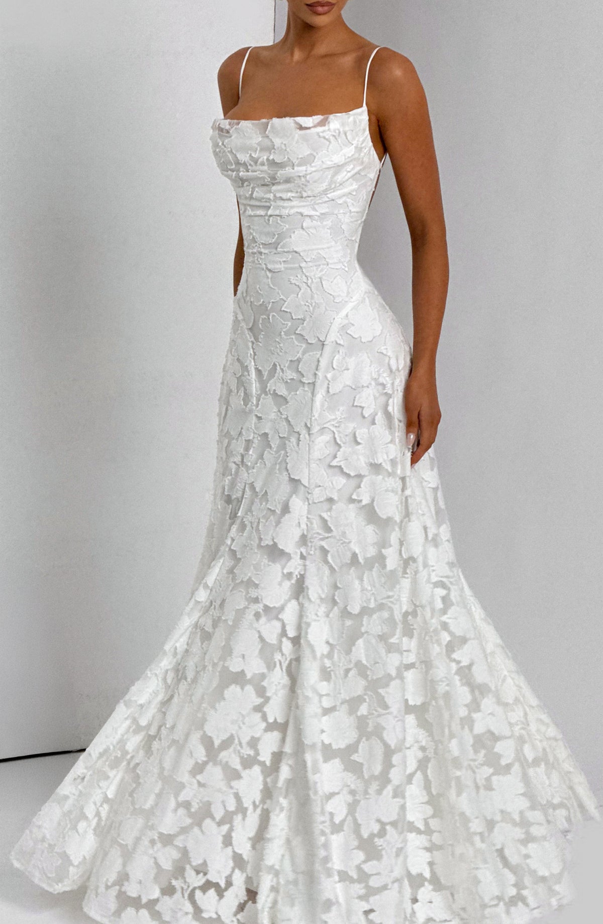 Angled view of the white floral maxi dress with a wide, flared skirt spreading out around the model's feet. 16
