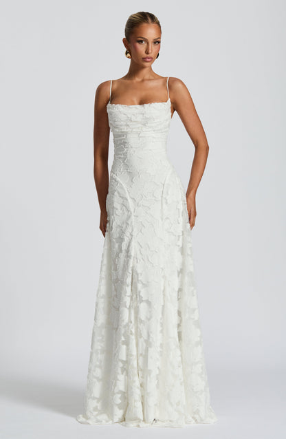 Front view of the white floral jacquard maxi dress with a cowl neckline, thin straps and a fitted waist. 8