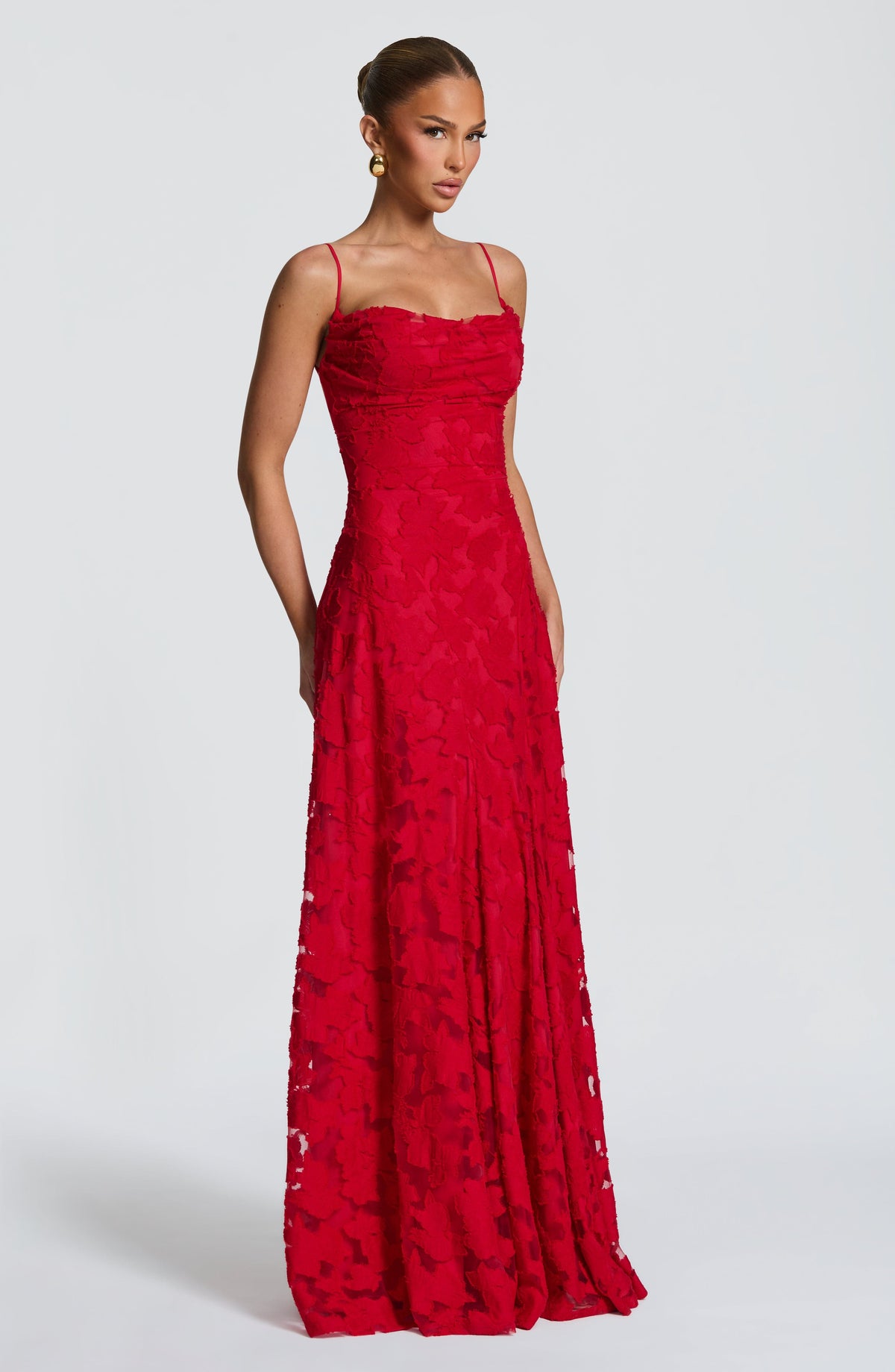 Three-quarter view of the red floral textured maxi dress with thin straps and fitted waist. 25