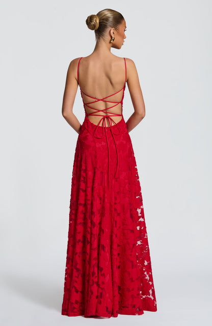 Back view of the red dress, showing the open back with criss-cross strap ties and a floral textured skirt. 27