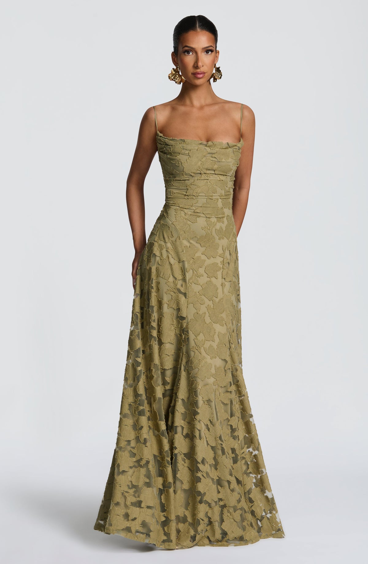 Model wearing the olive green floral textured maxi dress, front view, with large gold floral earrings. 29