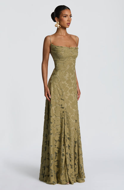 Side view of the olive green maxi dress, showing the cowl neckline, fitted waist and sheer-panelled floral skirt. 30