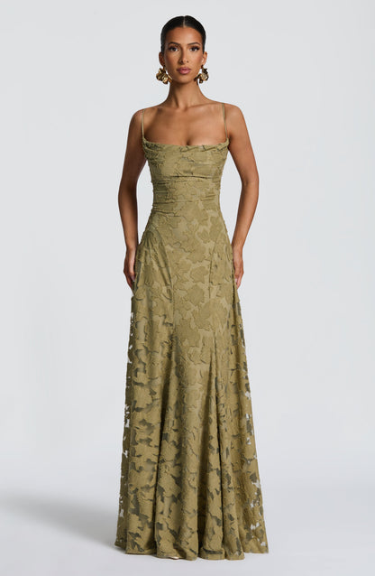 Front view of the olive green dress with the model's hands by her sides, showing the fitted bodice and long skirt. 32