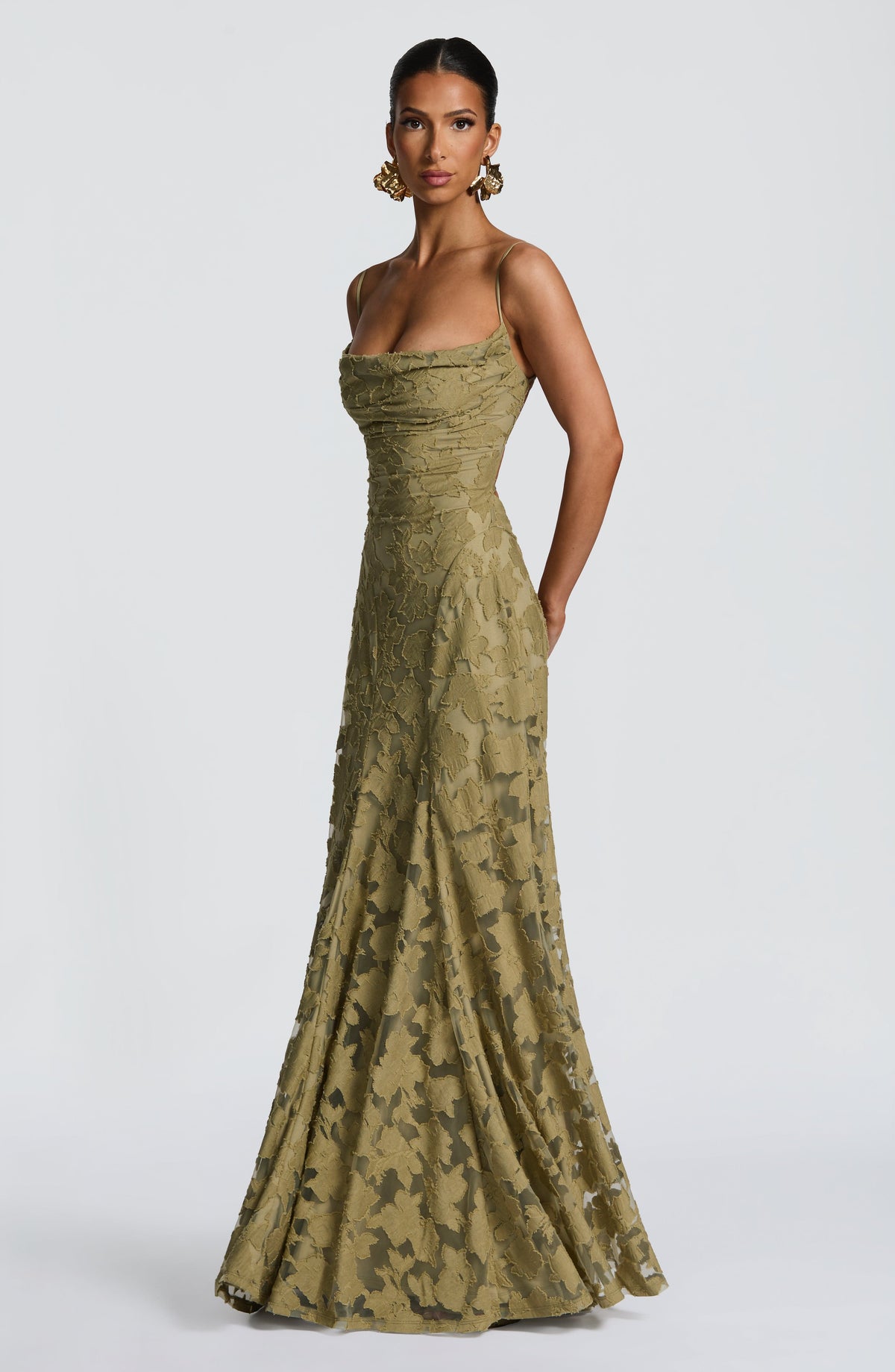 Angled view of the olive green dress, showing the draped neckline and the flowing skirt with sheer floral panels. 31