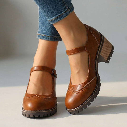 Tan-brown version worn indoors with cropped jeans, showing perforated toe cap, buckled ankle strap and chunky treaded sole 2