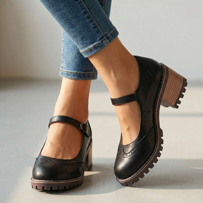 Black brogue-detail shoes worn with cropped jeans, close studio shot showing ankle strap, stacked heel and treaded sole 1