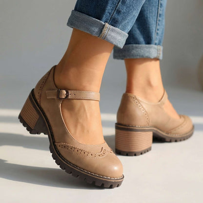 Beige version worn with cuffed jeans, seen from the side and back to show the buckle, stacked heel and tread sole. 3