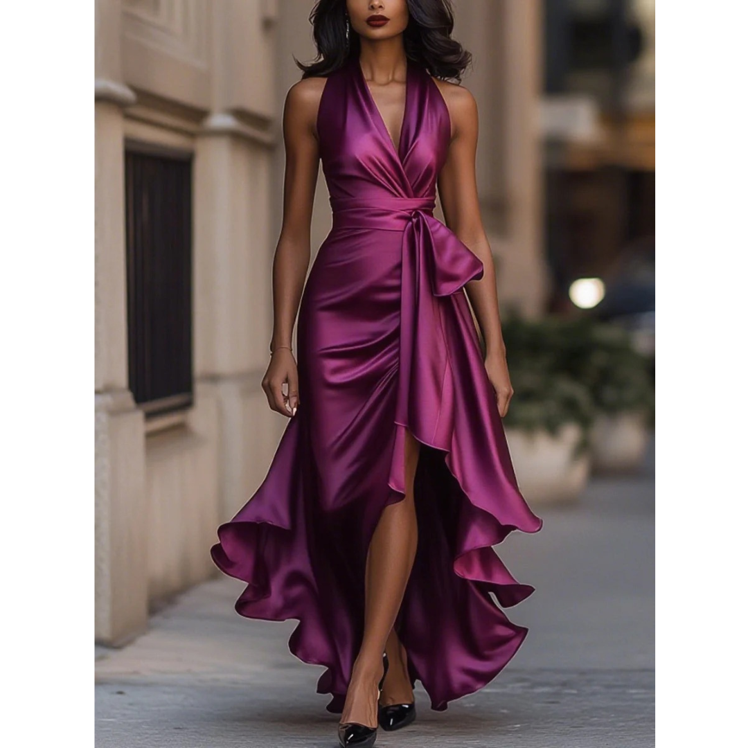 Model wearing the halter dress in magenta-plum satin, front view, showing the wrapped bodice and asymmetric ruffle skirt. 6