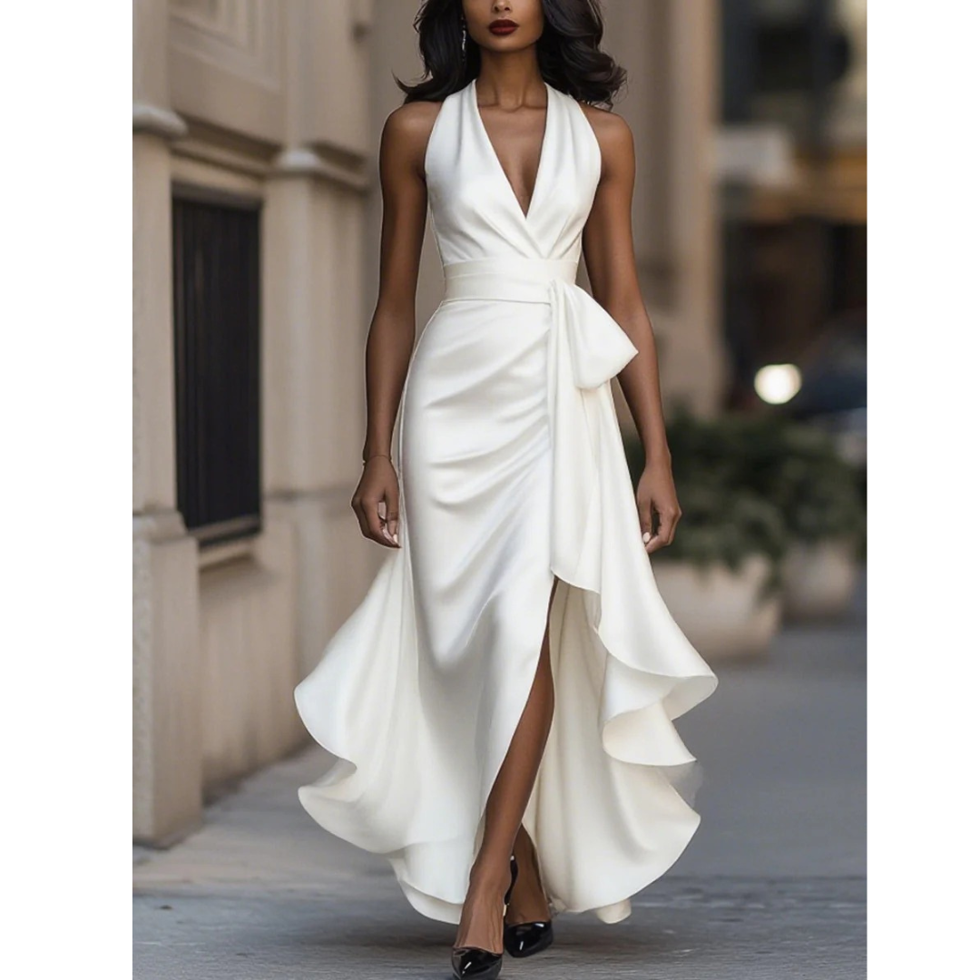 Front view of the halter dress in white satin on a model, showing the plunging draped bodice and high-low ruffle hem. 3