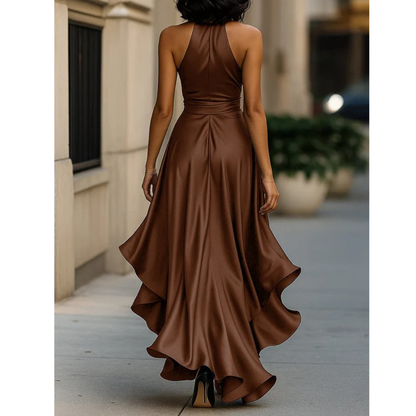 Back view of the copper-brown satin dress on a model, with halter neckline, waist seam and swirling ruffled hem. 11