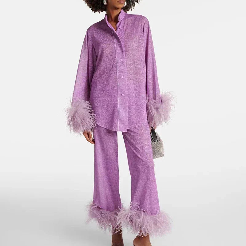 Model with curly hair wearing the lilac glitter set with stand collar, buttoned shirt and feather trim on sleeves and trouser hems. 3