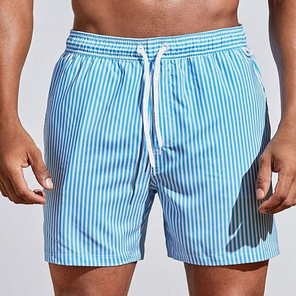 Model wearing light sky blue and white vertically striped swim shorts with a white drawstring, front view with arms relaxed. 9