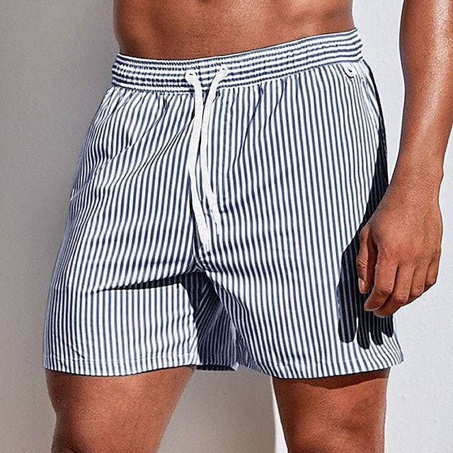 Model wearing navy and white vertically striped swim shorts with a white drawstring, showing the relaxed fit above the knee. 7