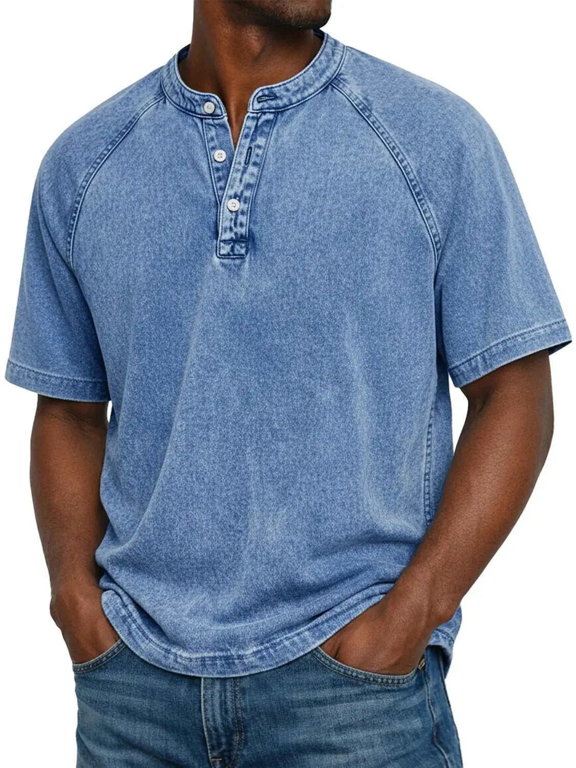Man wearing the short-sleeved raglan Henley in washed light blue, front view with three-button placket, paired with blue jeans. 2