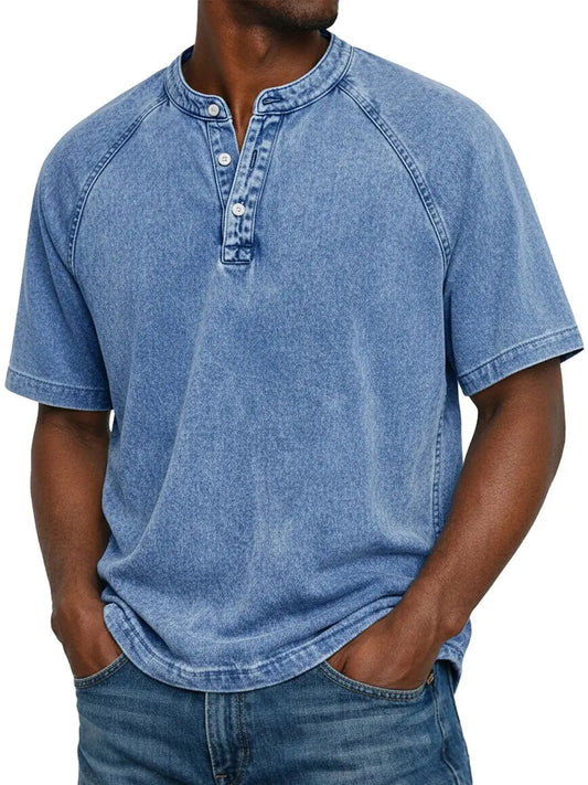 Man wearing the short-sleeved raglan Henley in washed light blue, front view with three-button placket, paired with blue jeans. 2