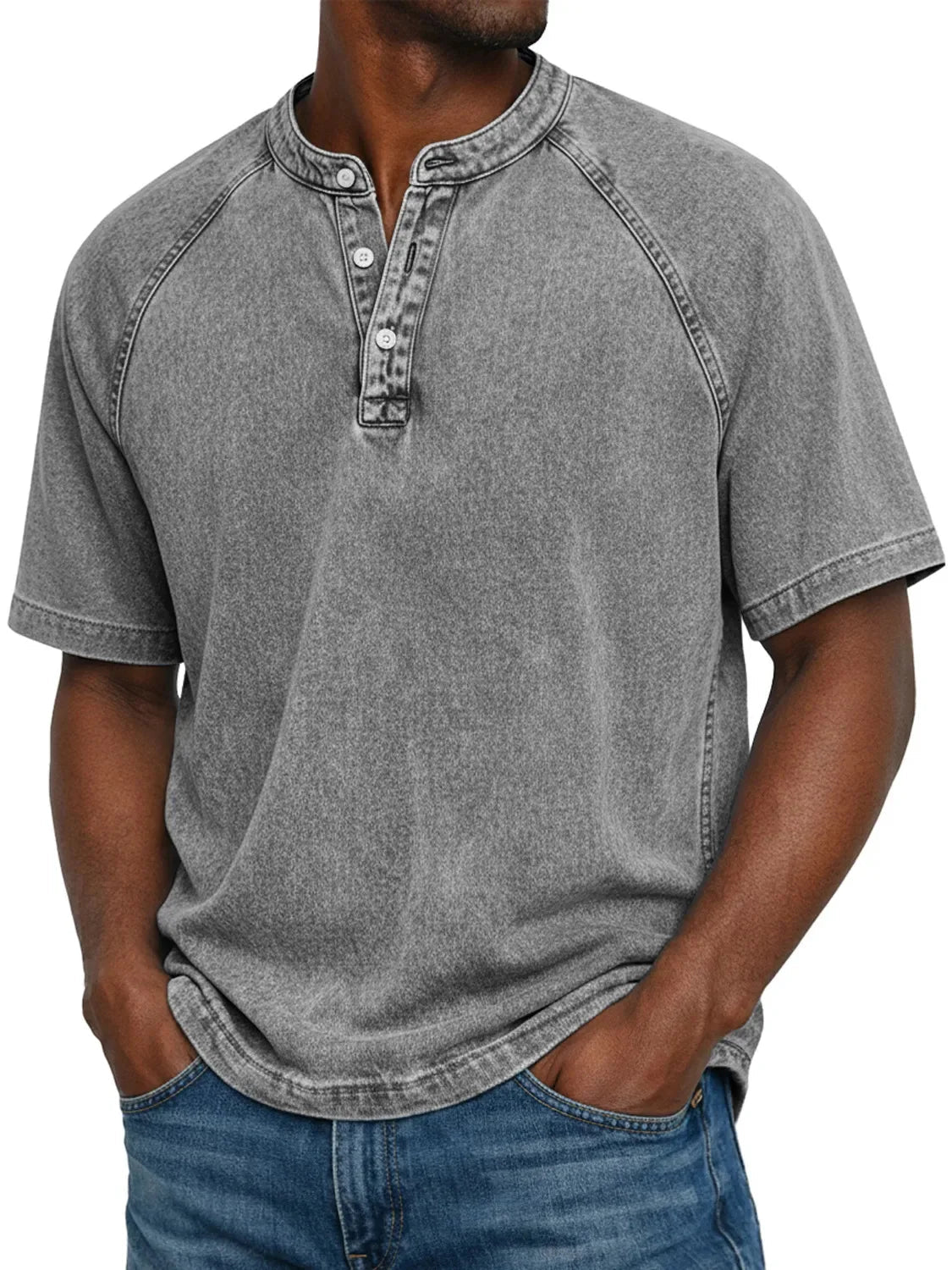 Man wearing the short-sleeved raglan Henley in washed mid grey, front view with buttoned placket, worn with blue jeans. 4