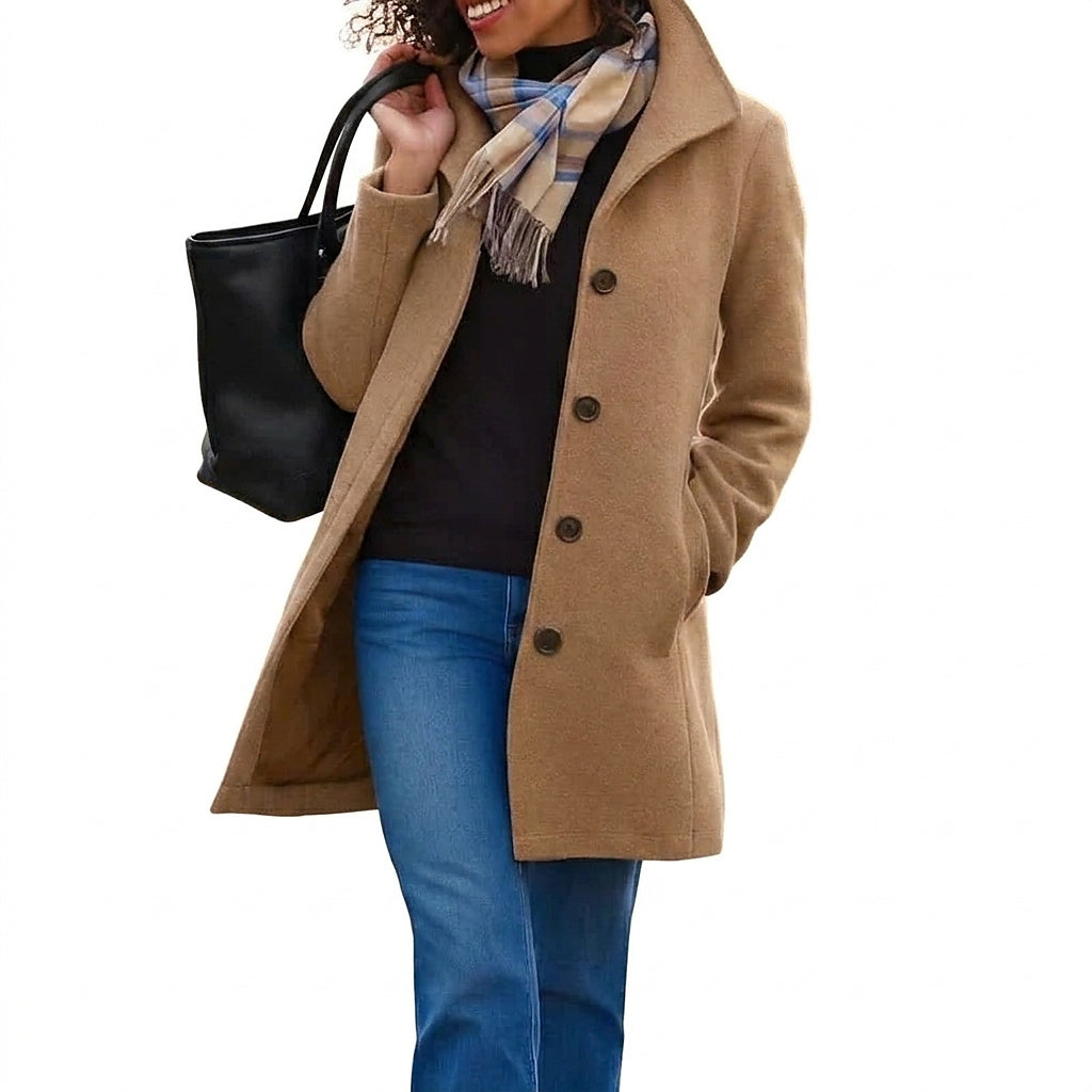 Camel button-up coat worn with a black polo neck, jeans, checked scarf and black tote bag against a plain white background. 1