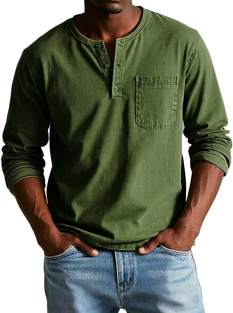 Model wearing the henley in olive green, front view with three-button placket, chest pocket and rolled sleeves, over light blue jeans. 2