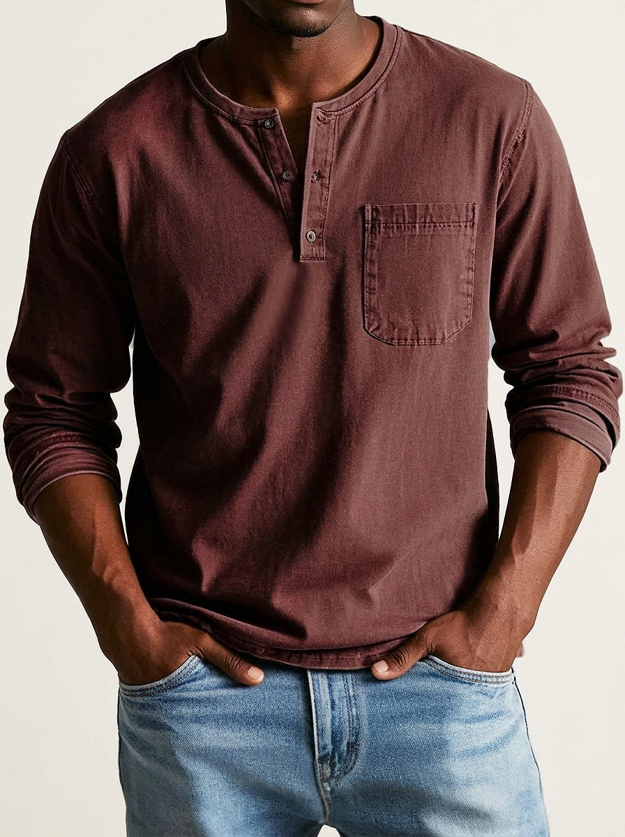 Henley in deep burgundy brown worn by a model, front view with three-button placket, chest pocket and rolled sleeves. 9