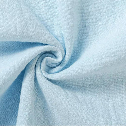 Close-up of light blue fabric twisted into a swirl, showing its soft, finely woven and gently crinkled linen-style texture. 8