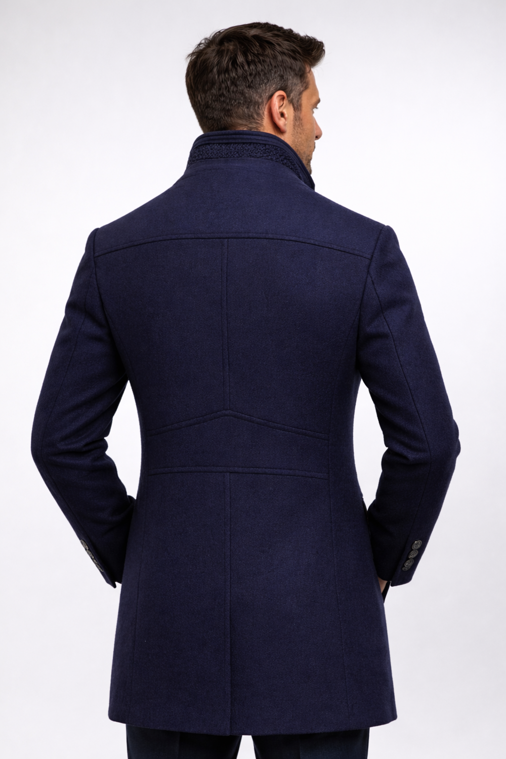 Model seen from behind in the navy coat, showing the back seams and cuff buttons 14