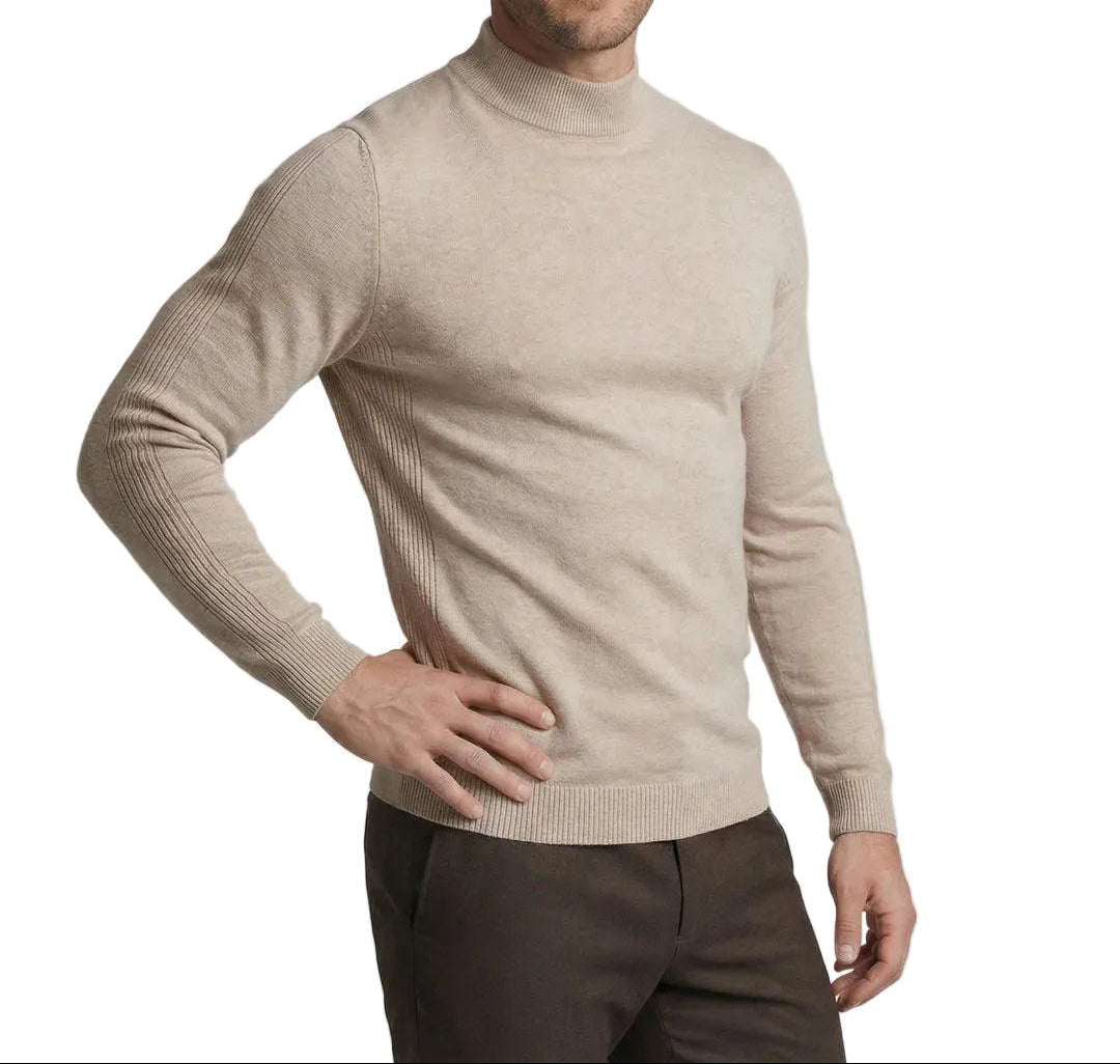 Model in the beige jumper, hand on hip, with brown trousers, shown from the side 1