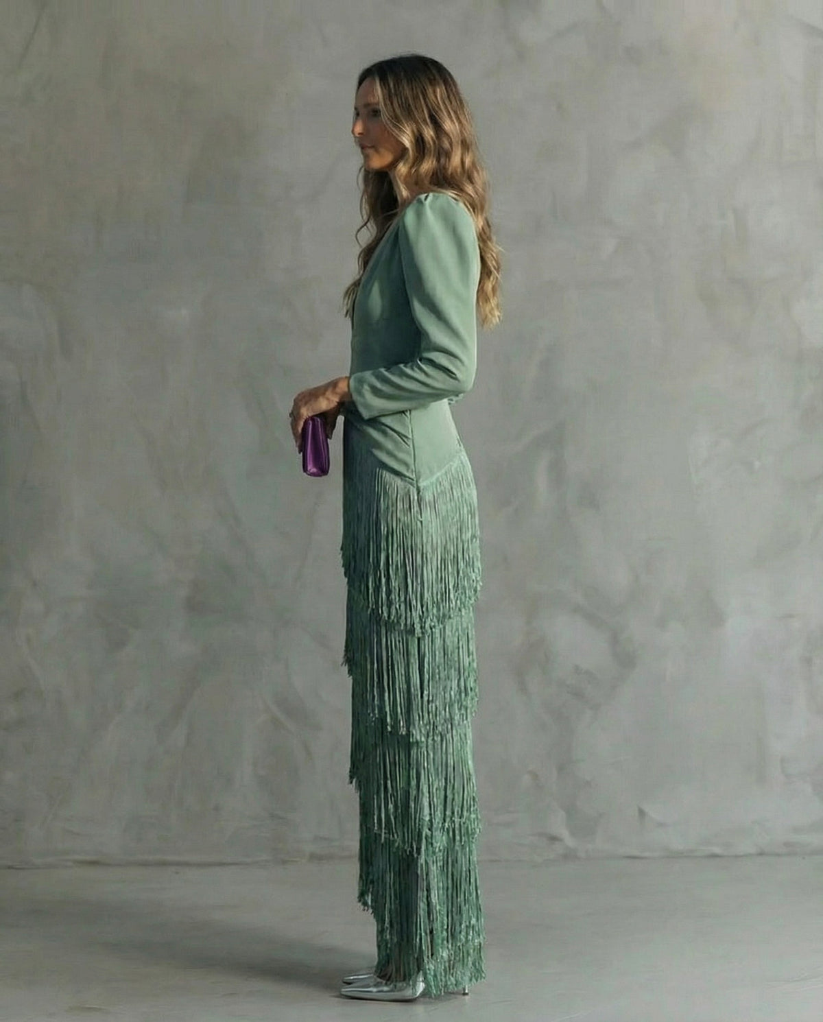 Side profile of the sage green dress, showing the layered fringe skirt and long sleeves 3