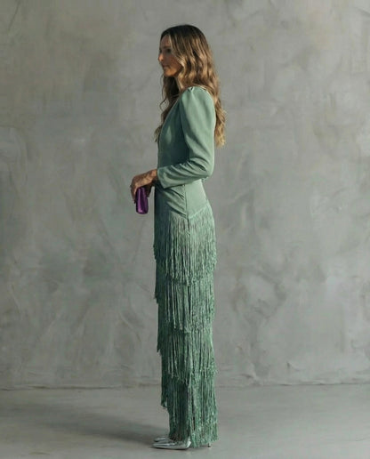 Side profile of the sage green dress, showing the layered fringe skirt and long sleeves 3