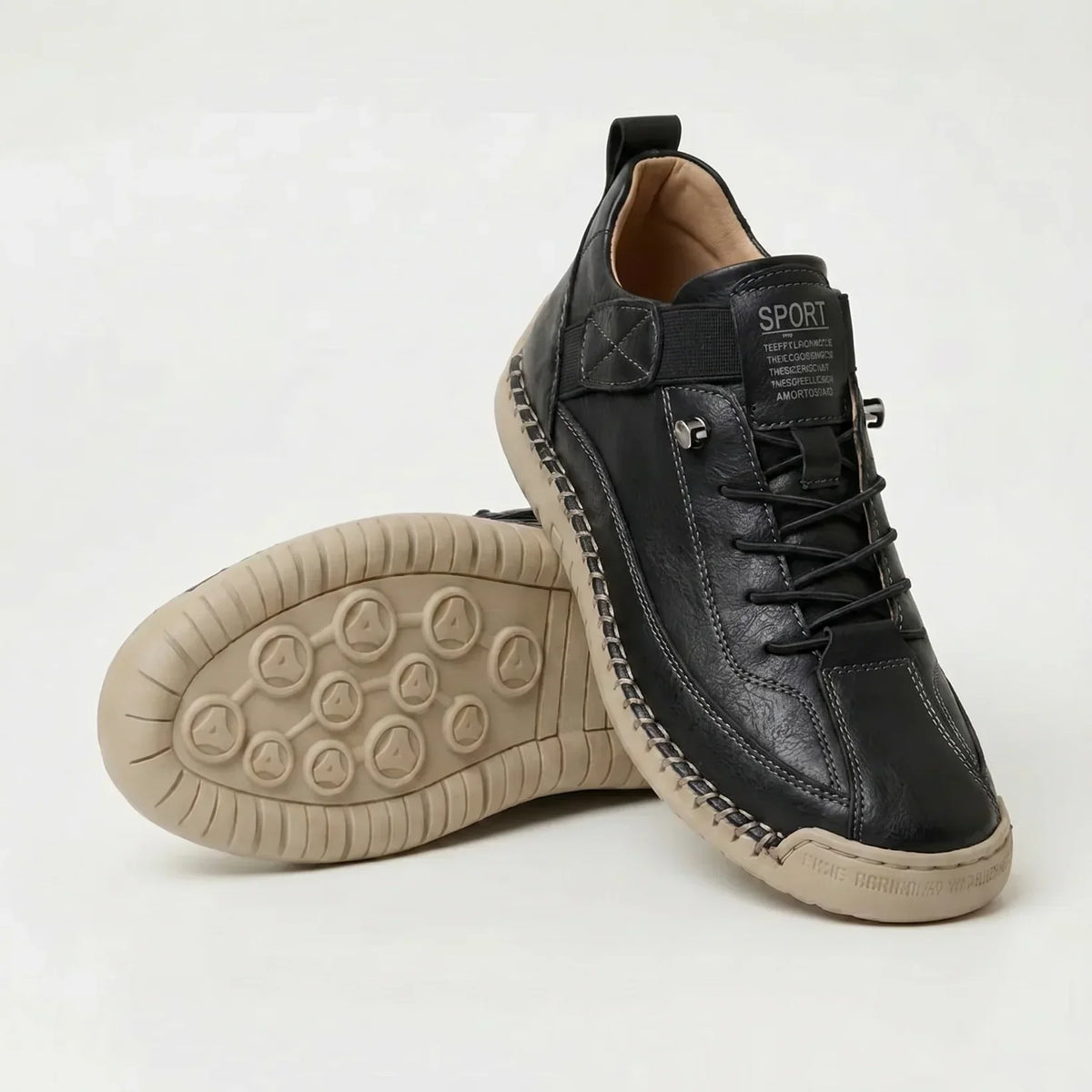 Black trainers with visible stitched welt and tan sole, one upright, one tilted showing the tread 12