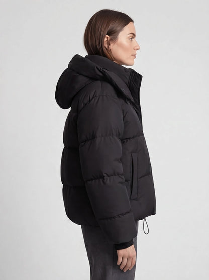 Side view of a model wearing the black padded jacket, showing the hood, side pocket and sleeve volume 5