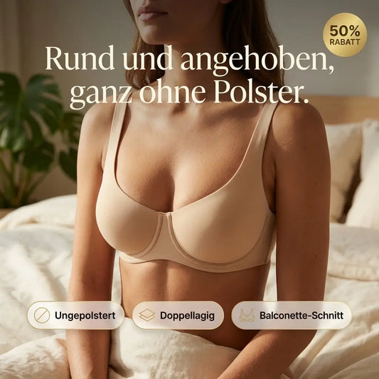 Woman sitting on a bed in a beige underwired balconette bra with wide straps, shown with a promotional banner and feature badges. 1
