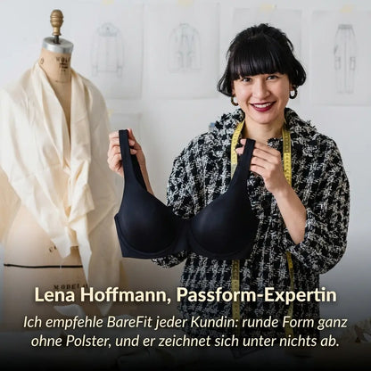 Smiling woman in a tweed jacket holding up a black balconette bra in a design studio, with a fitting expert's quote below. 5
