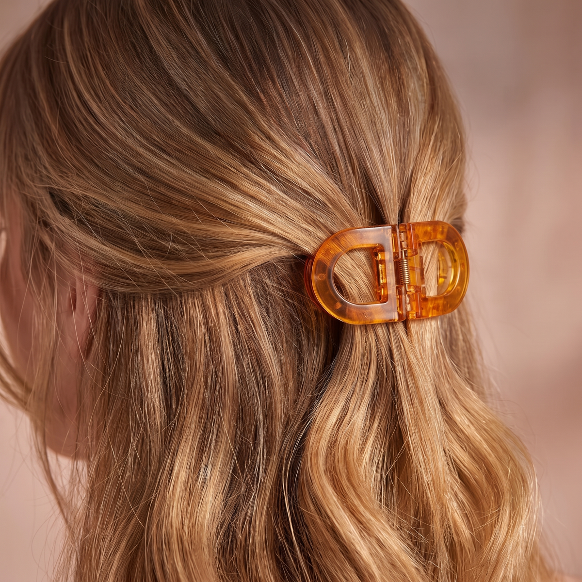 Back view of wavy blonde hair held half up with the amber flat clip, showing how slim it sits against the head. 13