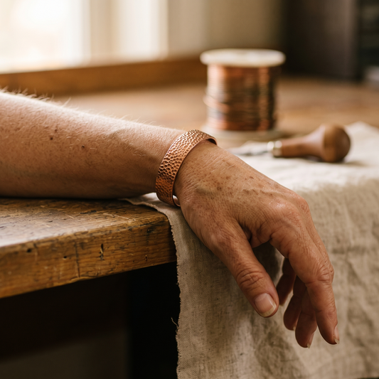 Cuff worn on a wrist, with a resting hand on a wooden bench and linen 2