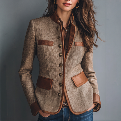 Cropped front view of a model wearing the herringbone jacket, buttoned with tan trim, over a brown shirt and jeans 1