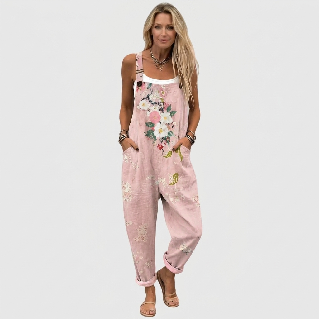 Full-length front view of a model in the loose pink overalls with turned-up hems, white vest underneath and flat sandals. 2