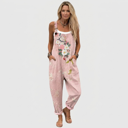 Full-length front view of a model in the loose pink overalls with turned-up hems, white vest underneath and flat sandals. 2