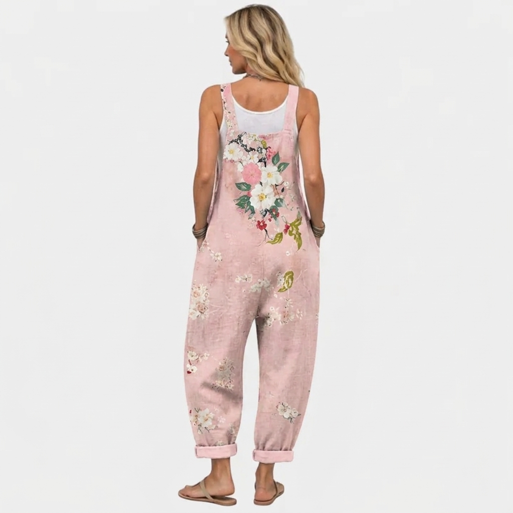 Back view of the overalls on a model, with the large flower bouquet print across the back and cuffed hems. 4