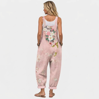 Back view of the overalls on a model, with the large flower bouquet print across the back and cuffed hems. 4