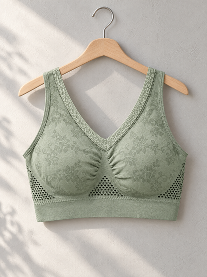 Sage green bra hanging on a wooden hanger against a sunlit wall 4