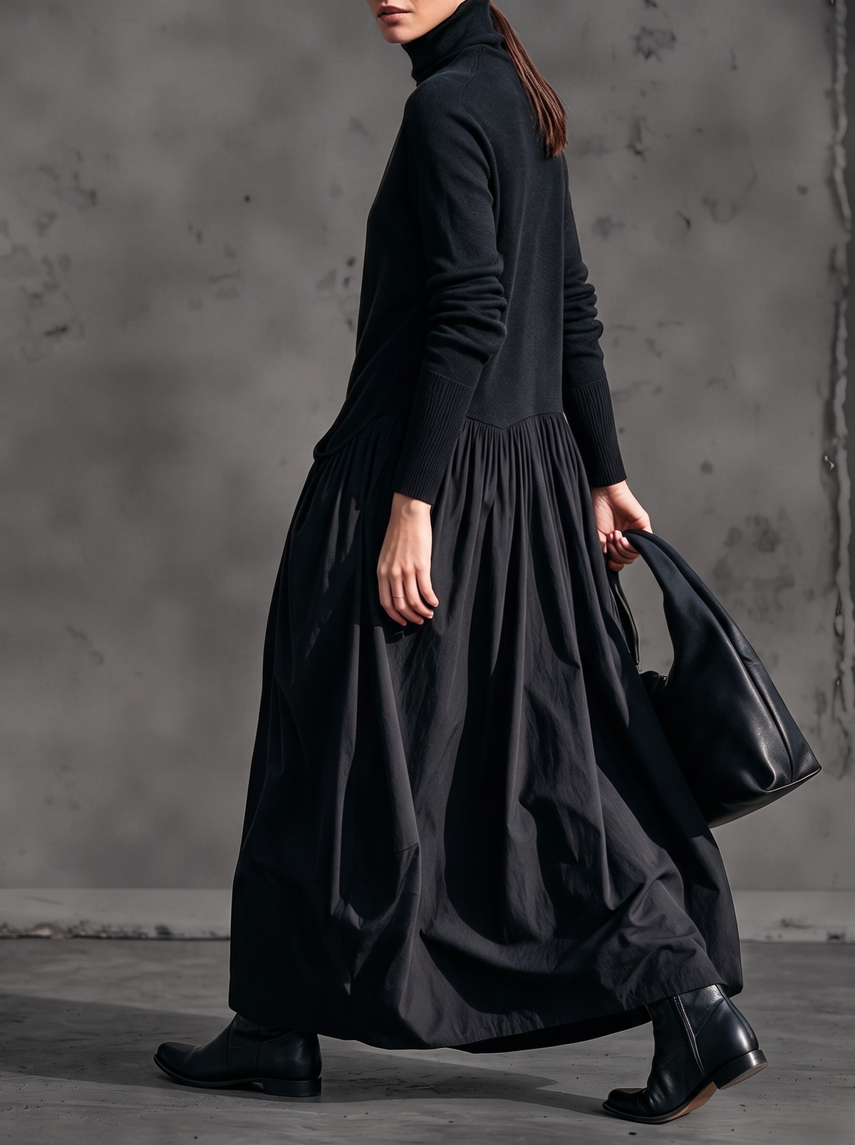 Black dress seen from the side on a walking model, showing the gathered waist and ribbed cuffs 2