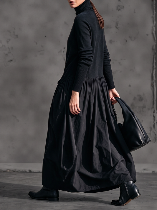 Black dress seen from the side on a walking model, showing the gathered waist and ribbed cuffs 2
