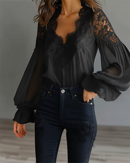 Black lace blouse in a front three-quarter view with sheer puffed sleeves and dark high-waisted jeans 8