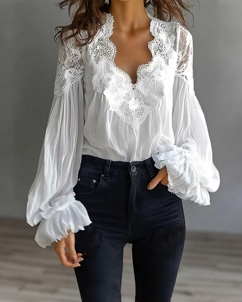 White blouse worn by a model with high-waisted dark jeans, one hand in pocket, lace V-neckline 3